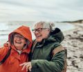 senior women laughing taking photo on the beach