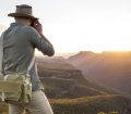 Man photographs sunset on a mountain range in Australia