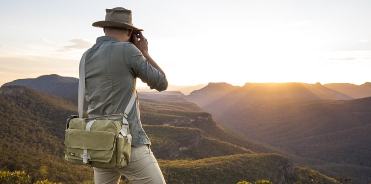 Man photographs sunset on a mountain range in Australia