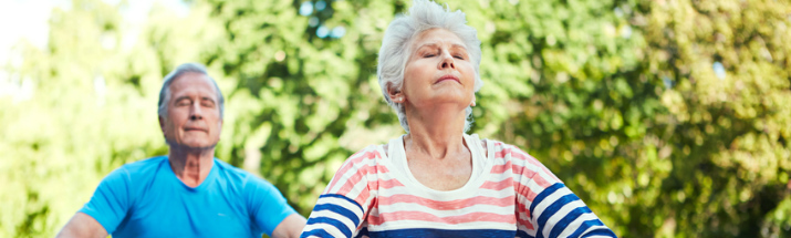 Mature people doing yoga on holiday