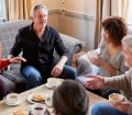 group of seniors sat talking over tea and cake
