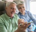 senio couple using mobile phone on airplane