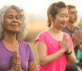 senior women practicing yoga outdoors