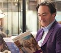 man smiling while reading Staysure policy book