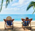 Couple relaxing on deck chairs at the beach