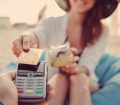 Woman on the beach making contactless credit card payment